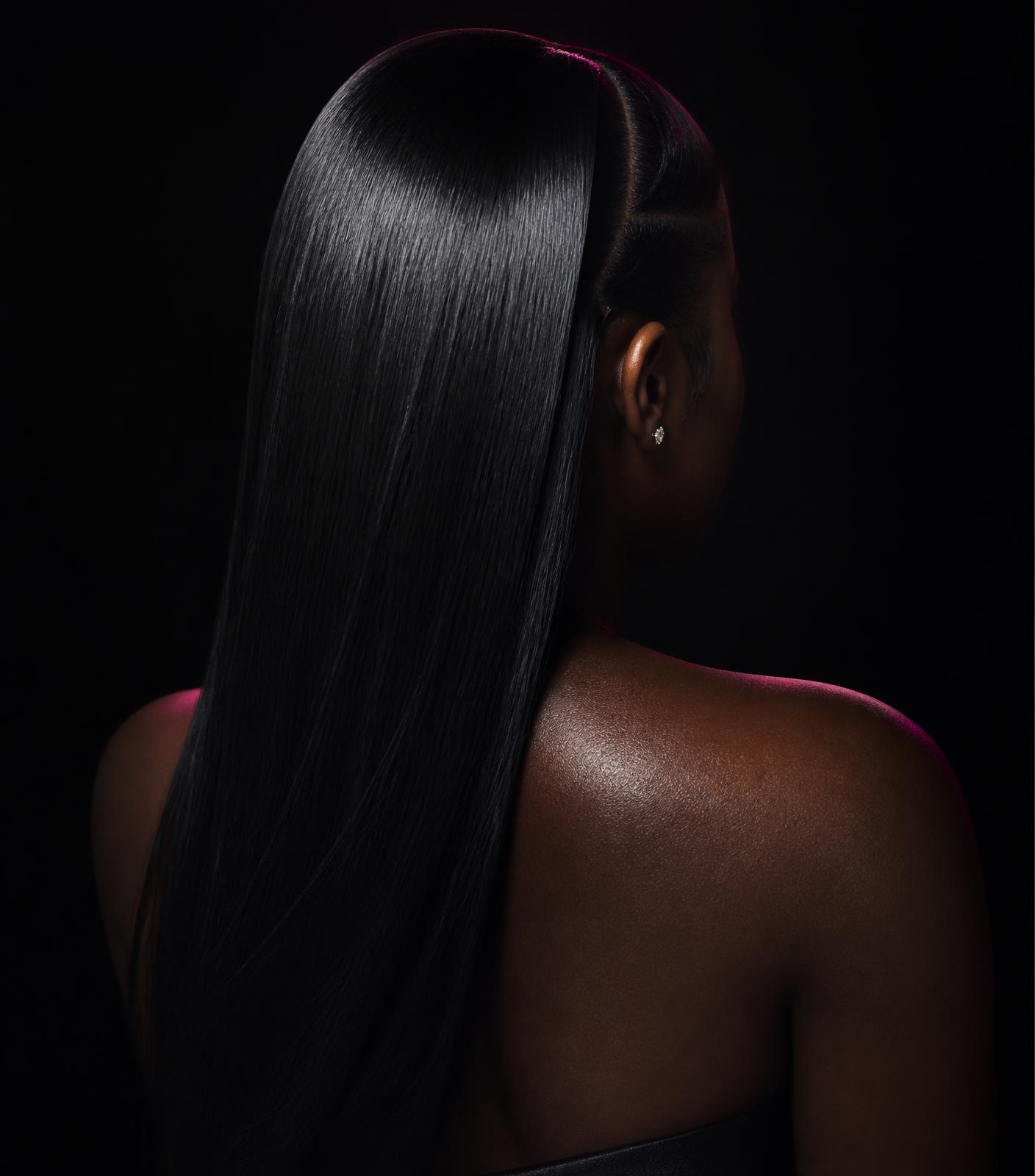 Sleek glueless wig install photographed against a black backdrop